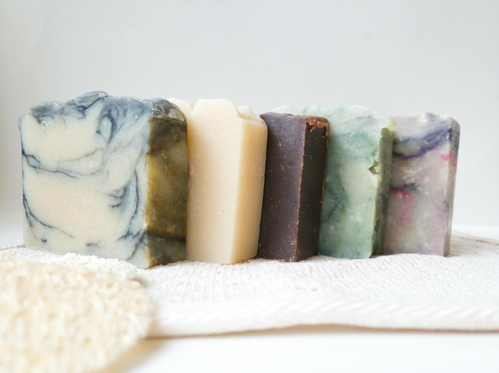 Close-up of various handmade soaps on a textured fabric, showcasing natural beauty and skincare.