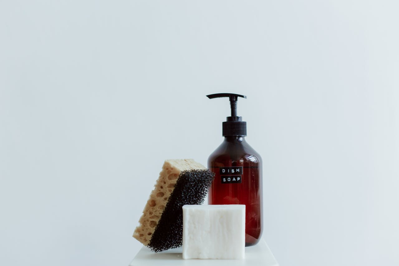Stylish arrangement of dish soap, sponge, and bar soap in a minimalist setting.