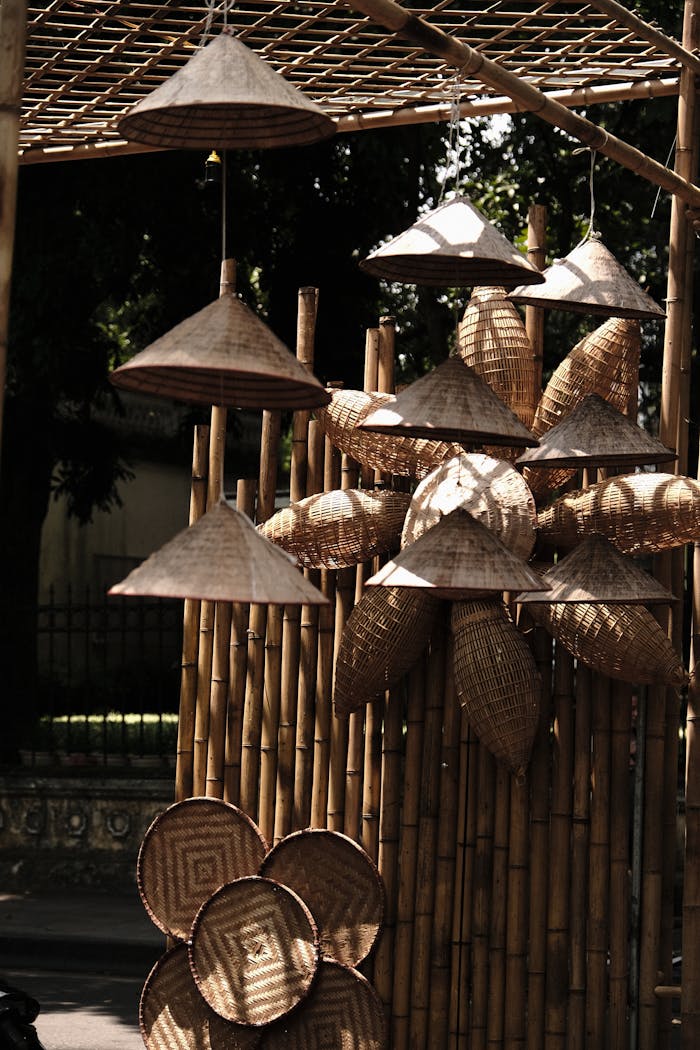 A traditional display showcasing handmade bamboo lamps and baskets in an outdoor setting.