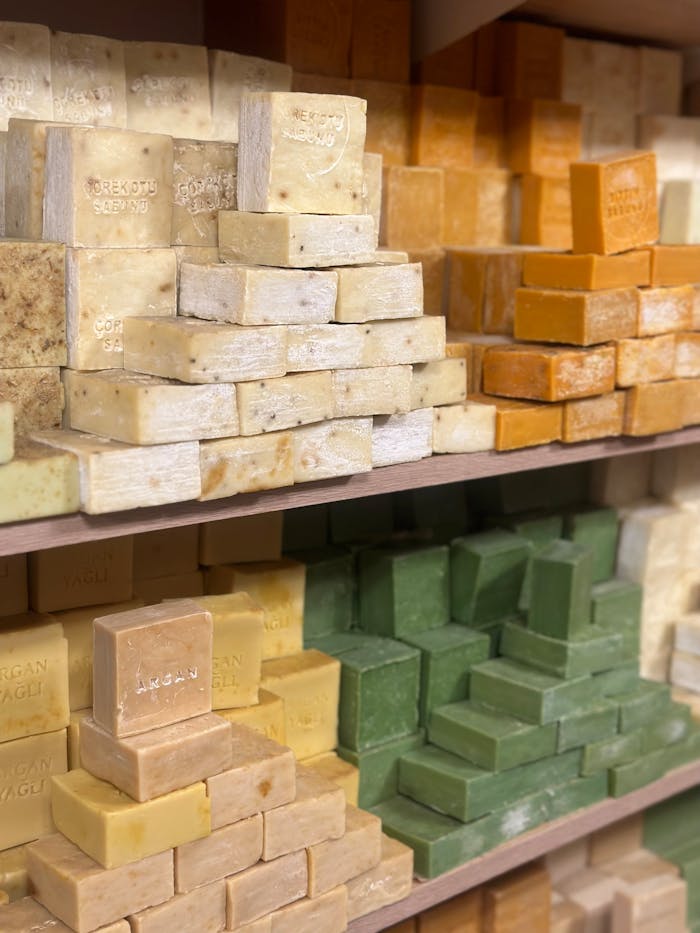 Stacks of colorful handmade organic soap bars displayed on shelves.