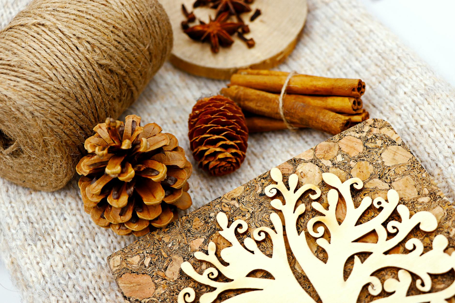 An eco-friendly craft setup with pine cones, spices, and cork emphasizing natural aesthetics.