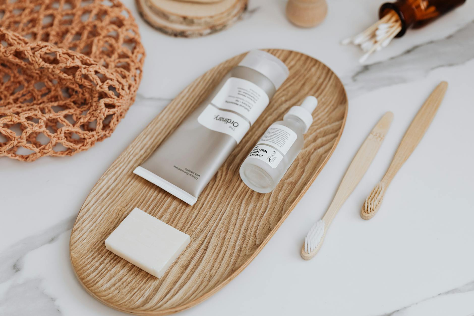 Flat lay of zero waste bathroom essentials including bamboo toothbrushes and skincare products.
